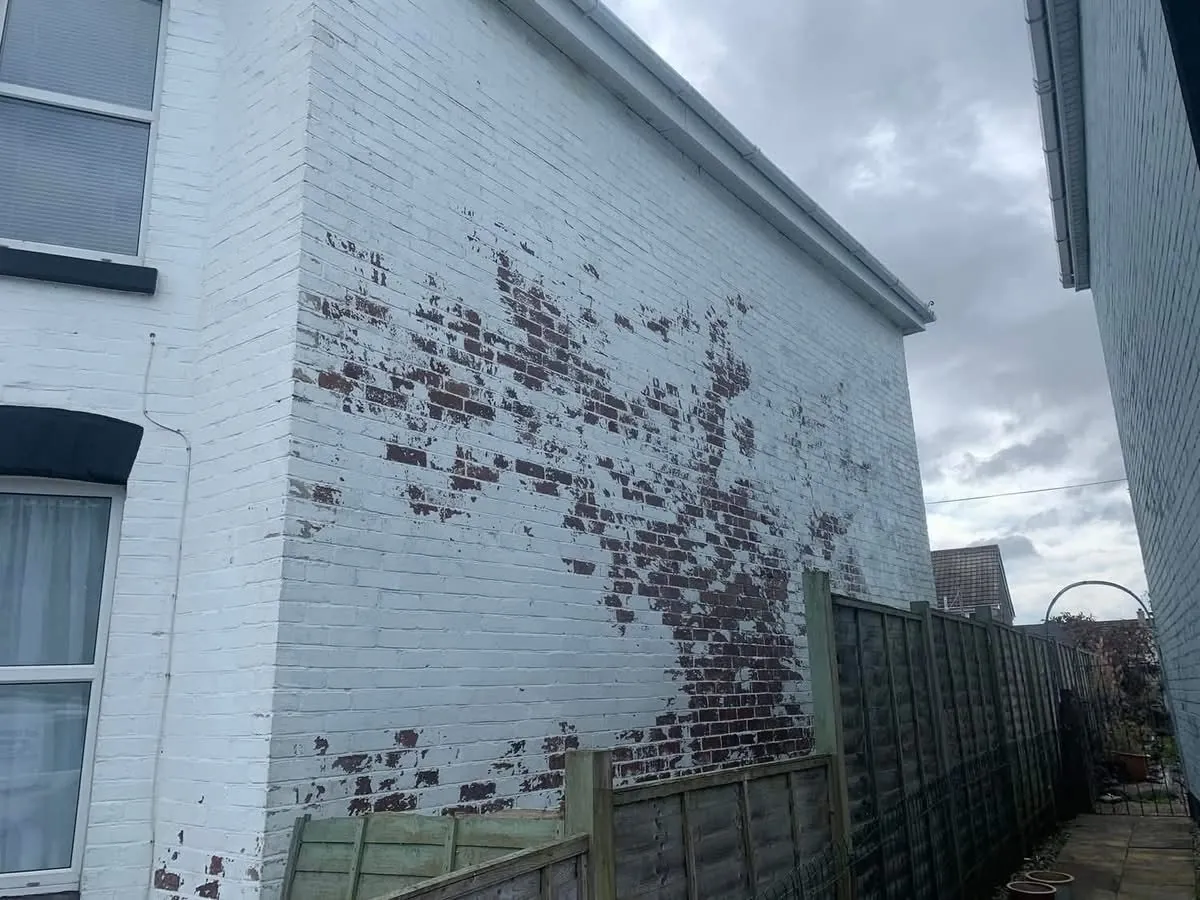 Peeling paint on a brick wall before redecoration in Marazion